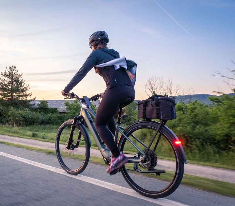 Kona hjólar eftir götu á Orbea Kemen Tour rafmagnsborgarhjóli