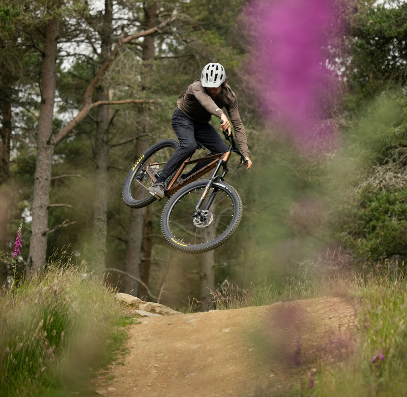 Maður flýgur upp í loftið á brúnu Orbea Laufey fjallahjóli