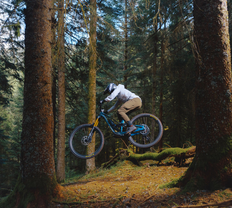 Maður brunar niður skóg í miðri fjallshlíð, og tekst á loft þegar hann þýtur niður hlíðina á Orbea Rallon Enduro fjallahjóli